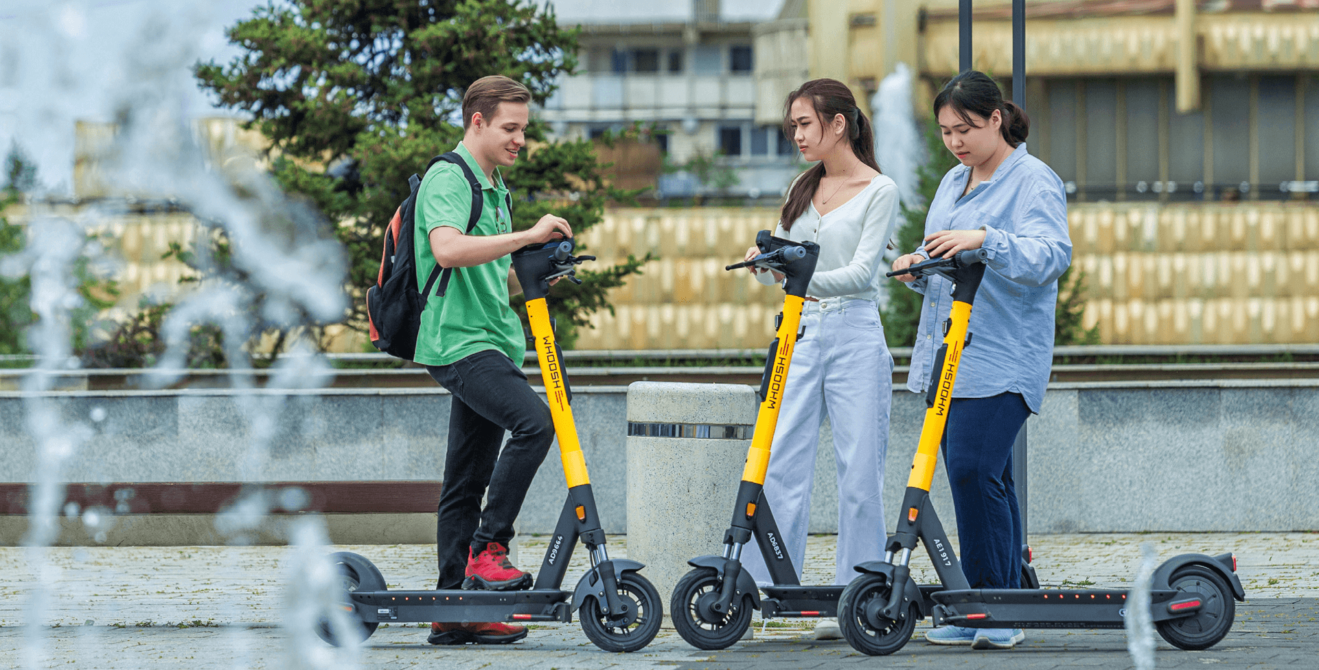 Люди на самокатах возле фонтана